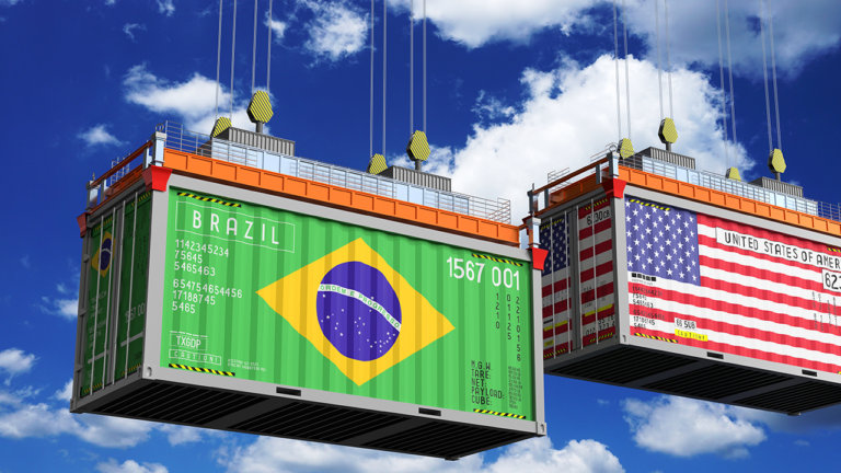 Contêineres de carga com as bandeiras do Brasil e dos Estados Unidos, representando o comércio internacional e as tarifas americanas que afetam as exportações brasileiras